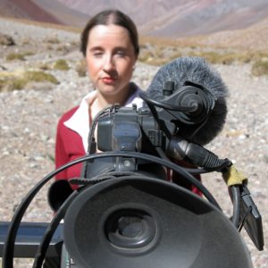 Jen reporting behind camera square