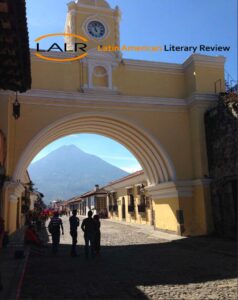 A mountain is visible in the distance from under a yellow colonial archway with a cobblestone street below. Cover page of the Latin American Literature Review